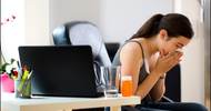 Woman Sneezing at Her Desk Woman Sneezing at Her Desk