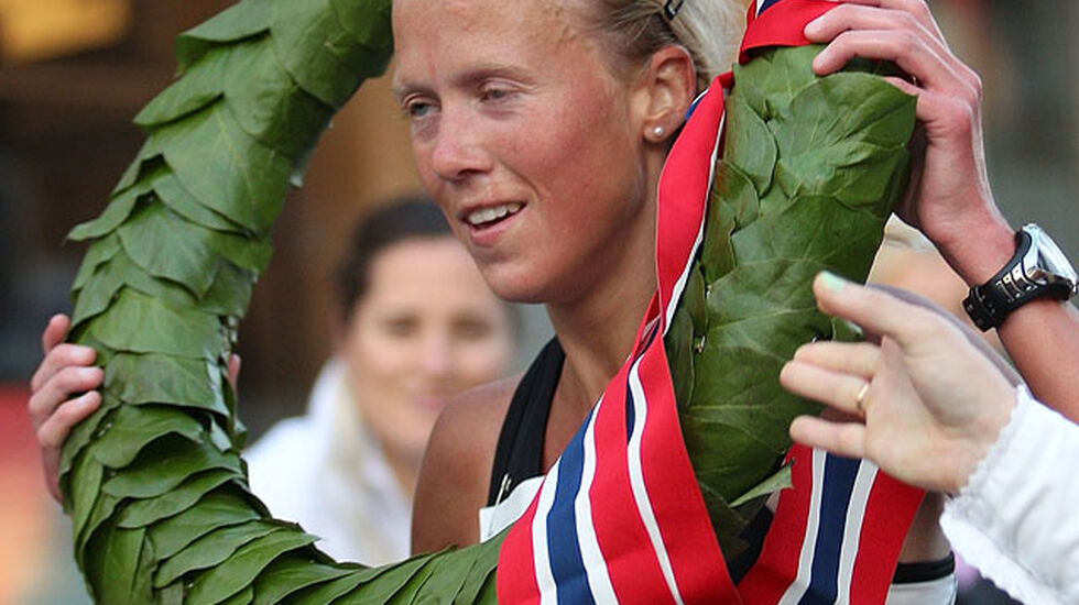 Marthe Katrine Myhre får seierskransen rett før målpassering.