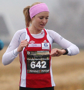 Mot rekord: Karoline Bjerkeli Grøvdal passerer 8 km-skiltet og sjekker passeringstida. Hun kan konstatere at hun ligger meget godt an. Kirsten Marathon Melkevik hadde den gamle løyperekorden på gode 33.20. Nå ble det en forbedring av rekorden med over ett og et halvt minutt.