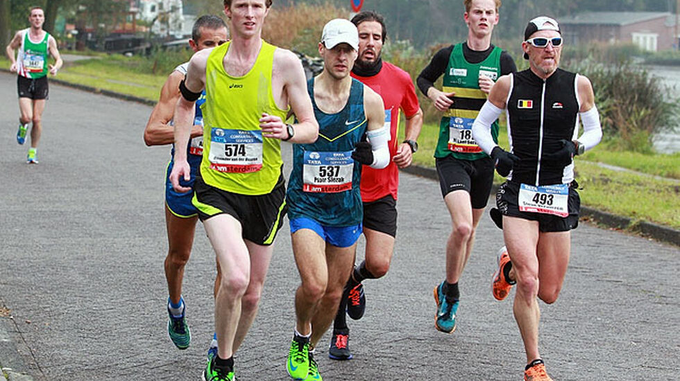 Etter 14 km: Maratonløypa følger her Amstelelva oppover i det grønne i drøye 5 km og vender så og tilbake på andre siden av elva. På bildet har dagens beste norske deltaker, Mikkel Sørensen (i NTHUIs grønne drakt med gul og svart stolpe) funnet seg et fint felt å løpe i.