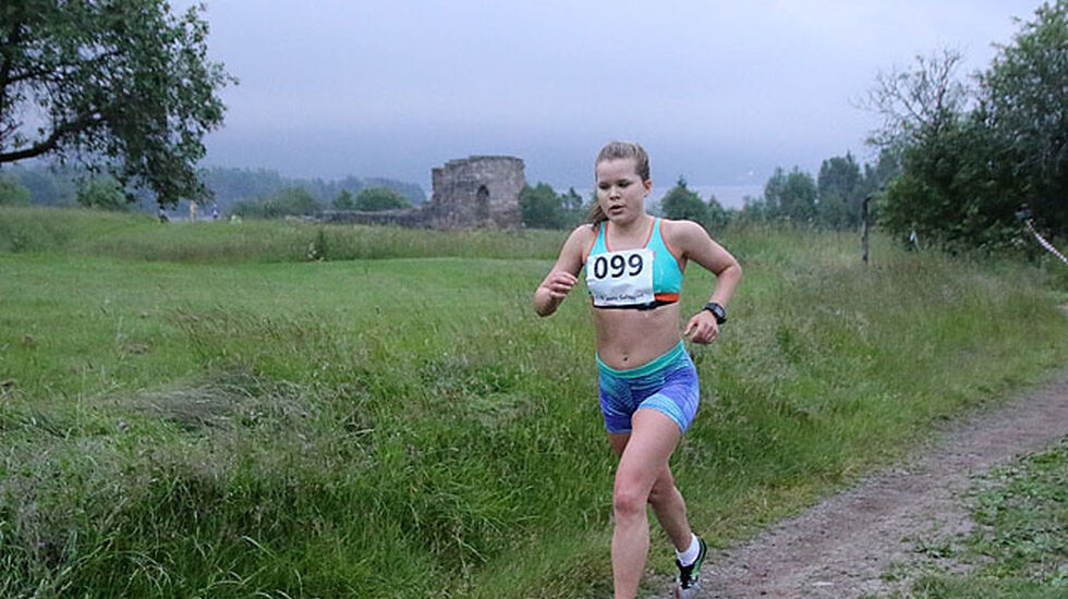 Tonje Gresslien med 1 km igjen å løpe. Bak henne ser vi Kirkeruinene og vi skimter såvidt Maridalsvannet som nesten går i ett med tåka som kom sigende. Foto: Heming Leira