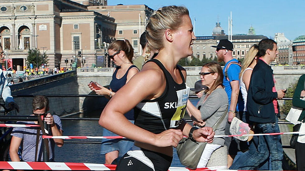 Beste norske: Pernilla Epland passerer etter 12 km start og målområdet. I bakgrunnen ser vi operaen og broa hvor løperne stilte opp til start og hvor det også er målgang. (Foto: Kjell Vigestad)