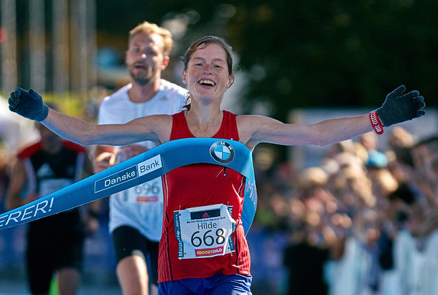 Hilde Aders jubler idet hun krysser mållinja som vinner av Oslo Maraton 2015. (Foto: Stian Schløsser Møller) 