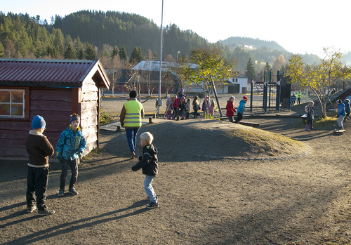 Høstbilde av unger i leik bak Årlivoll skole