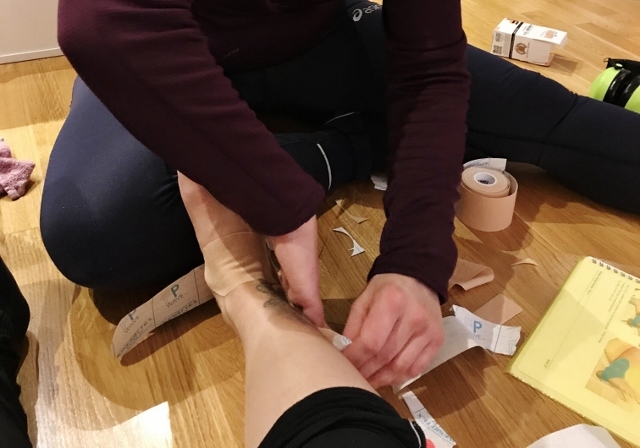 Marthe setter på kinesiotape på den vonde ankelen