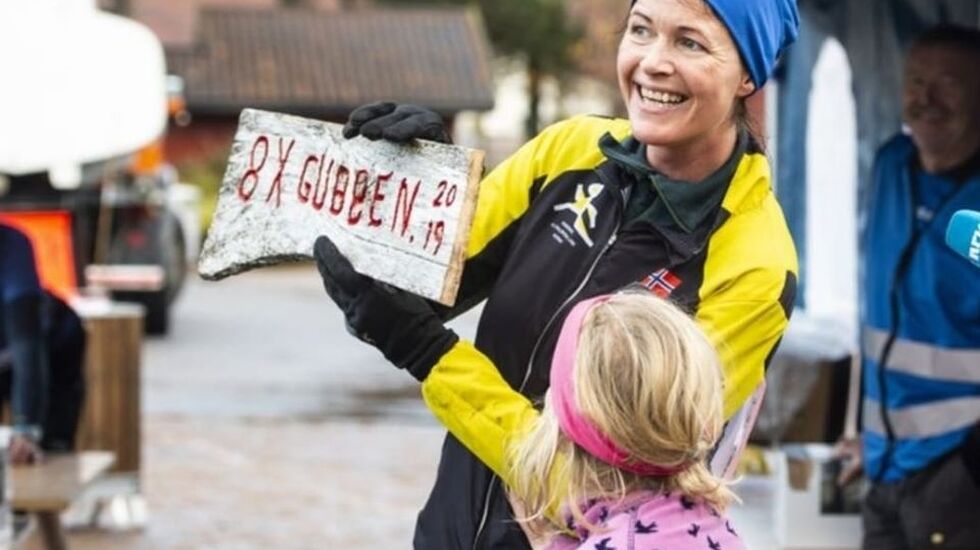 Øyunn Bygstad har fullført den 8-dobbelte Skaugubben, og holder stolt opp skiltet som viser dette. Datteren Synne er stolt av mamma. (Foto: Magnus Antonsen)