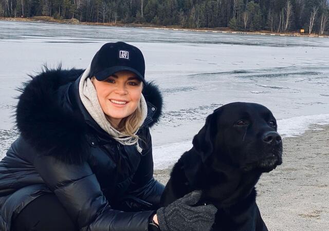 Camilla Balstad sitter sammen med hunden sin.