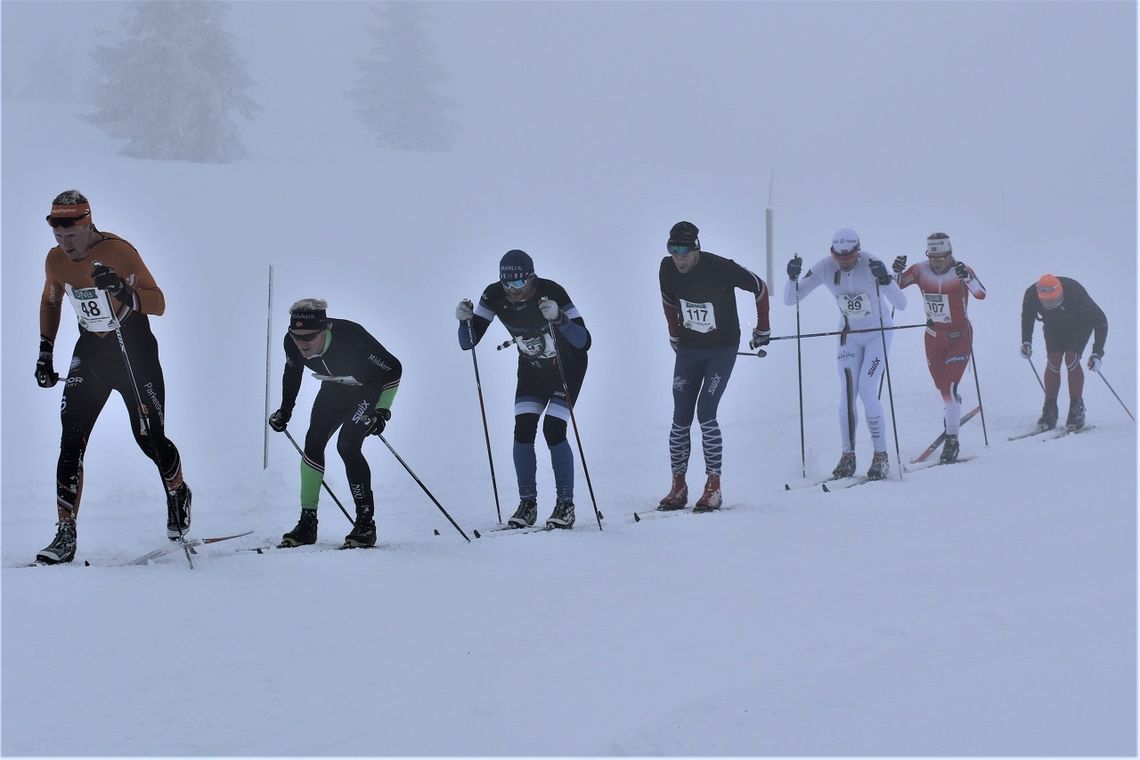 Lotta Udnes Weng (nr. to fra h.) sammen med  seks mannlige løpere på en lang, lang rekke like ved Storåsen etter 25 km. (Foto: Kjell Arild Andersen)
