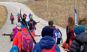Elevar med skiutstyr på veg til bussen