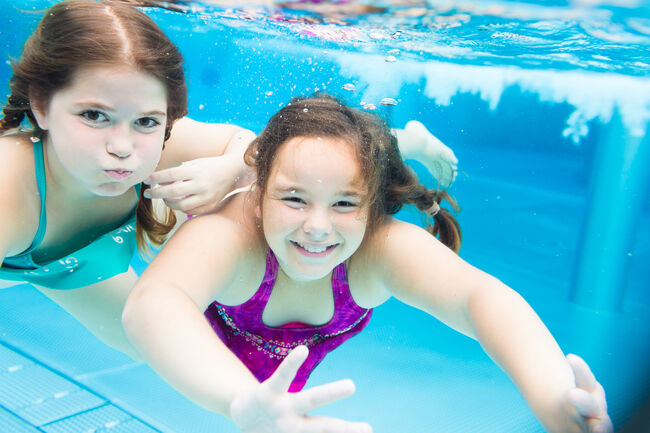 Two female friends swimming underwater