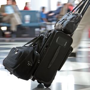 Illustrasjonsbilde av en reisende med koffert på flyplass
