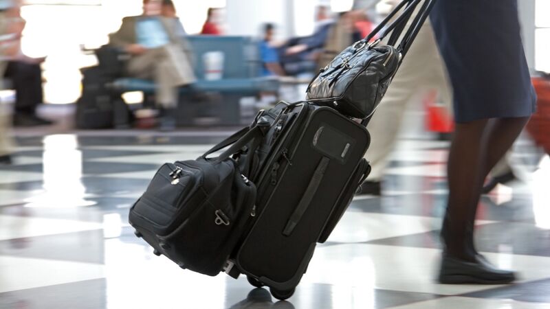 Illustrasjonsbilde av en reisende med koffert på flyplass