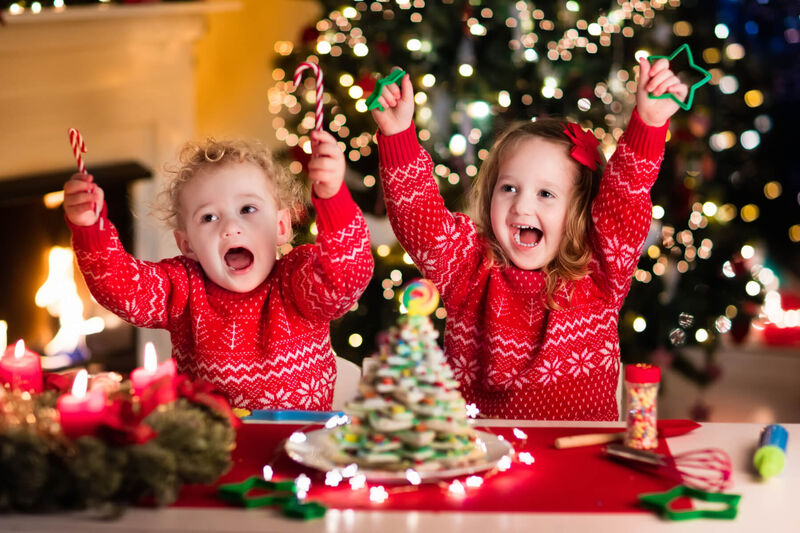 Illustrasjonsbilde av to barn som pynter pepperkaker i et julepyntet hus