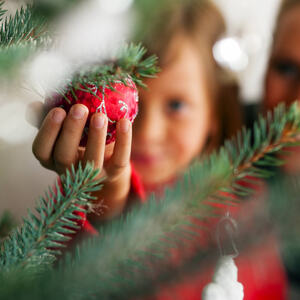 Illustrasjonsbilde av et barn og en mor som pynter juletreet