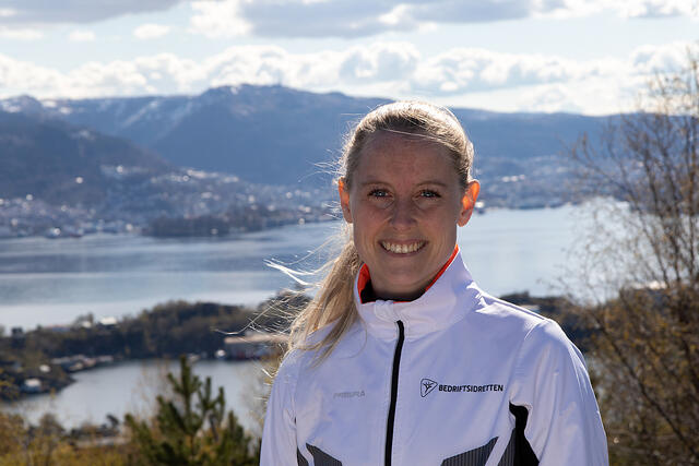 Trudi Aaltvedt i Bedriftsidretten Vestland kan ønske velkommen til årets Ti på topp. I bakgrunnen ser vi Ulriken, som er at av turmålene i årets aksjon. (Foto: Arne Dag Myking)