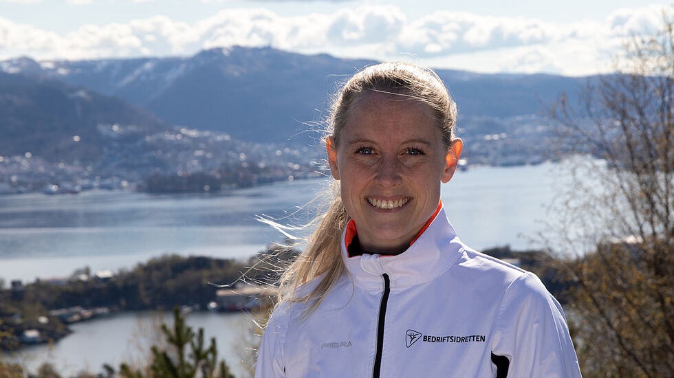 Trudi Aaltvedt i Bedriftsidretten Vestland kan ønske velkommen til årets Ti på topp. I bakgrunnen ser vi Ulriken, som er at av turmålene i årets aksjon. (Foto: Arne Dag Myking)