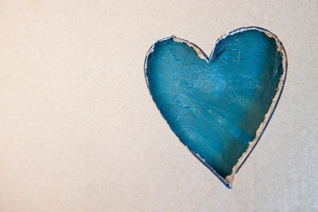 Blue heart shape cut from cardboard. Concept of St Valentines day