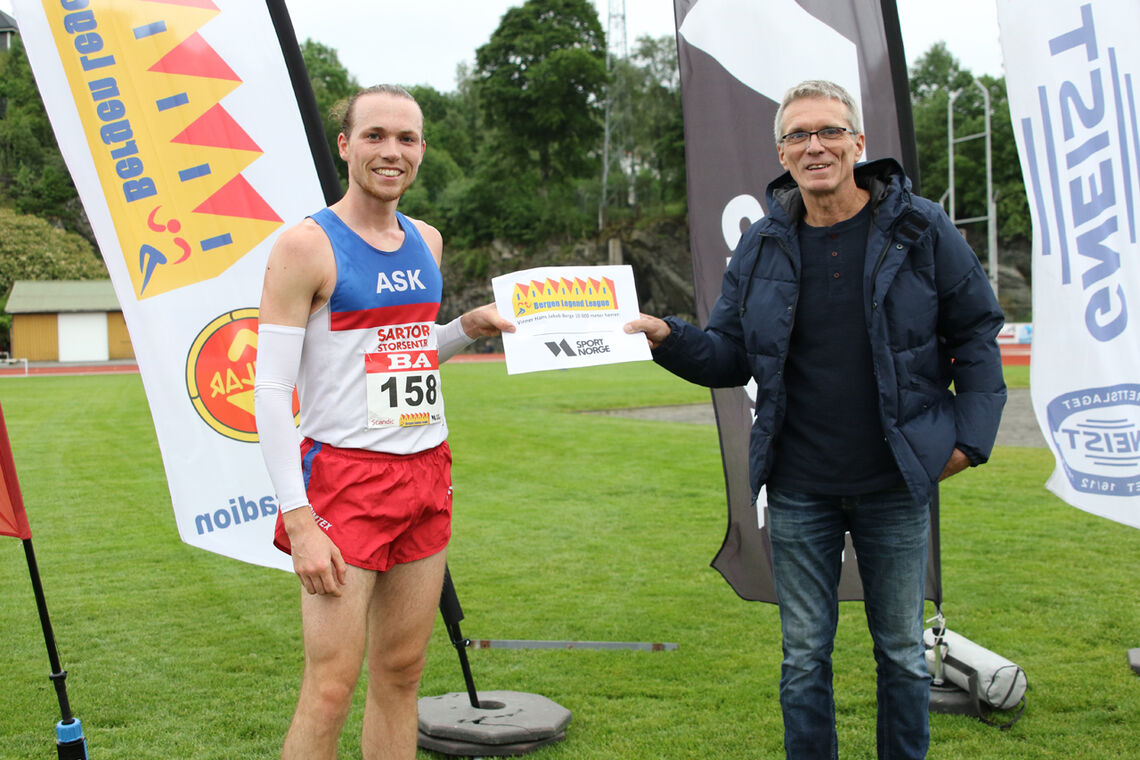 Marius Sørli får overrakt premien for seier på 10000 meter fra han som har gitt navn til stevnet, Hans Jakob Berge. (Foto: Tom Roger Johansen)