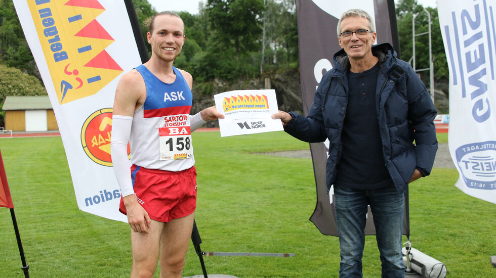 Marius Sørli får overrakt premien for seier på 10000 meter fra han som har gitt navn til stevnet, Hans Jakob Berge. (Foto: Tom Roger Johansen)