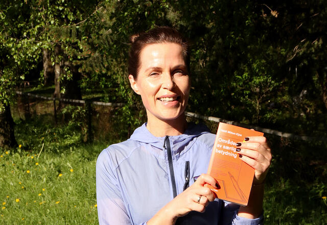 Heidi Mittun-Kjos kan stolt vise fram sin nye roman, «Områder av særlig betydning». (Foto: Runar Gilbeg)
