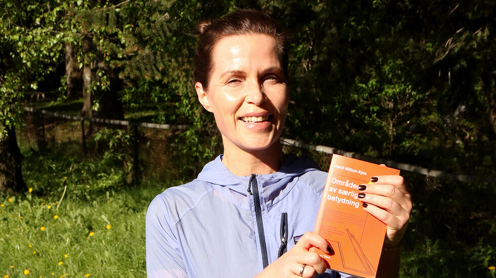 Heidi Mittun-Kjos kan stolt vise fram sin nye roman, «Områder av særlig betydning». (Foto: Runar Gilbeg)