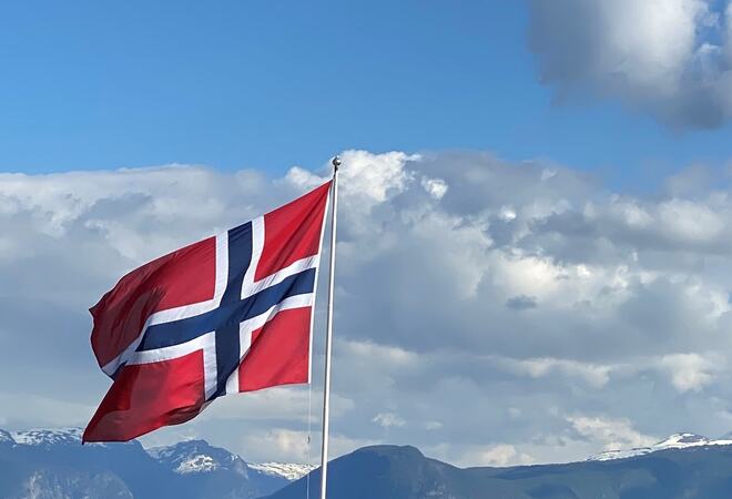 Norsk flagg som vaiar i vinden.