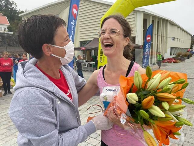 Arrangøren delte ut fire blomsterbuketter til noen de plukket ut i farta, her er det en lykkelig 5 km løper som ble overrasket med blomster av funksjonær Beate Sommer. (Alle foto: Janicke Yttervik )
