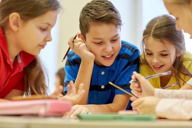 group of students talking and writing at school