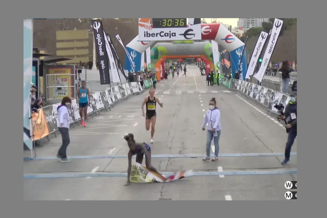 Norah Jeruto Tanui faller over målstreken mens Karoline Bjerkeli Grøvdal kommer i stor fart bak. (Skjermprint fra streaming)