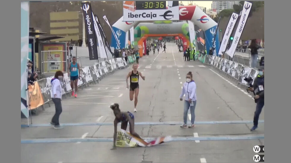 Norah Jeruto Tanui faller over målstreken mens Karoline Bjerkeli Grøvdal kommer i stor fart bak. (Skjermprint fra streaming)