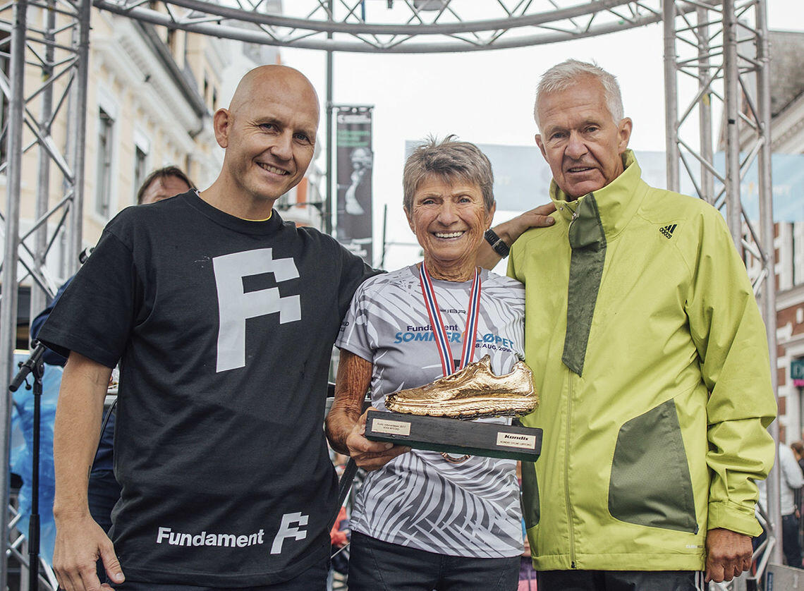 En av Norges råeste veteraner - Vera Nystad, har akkurat mottatt Kondis´ gullsko for sin innsats i 2021. Her er hun avbildet sammen med Finn Kollstad (tv.) og Jack Waitz, fra da hun fikk skoen for første gang, i 2017. (Foto: Torleiv Klungland)