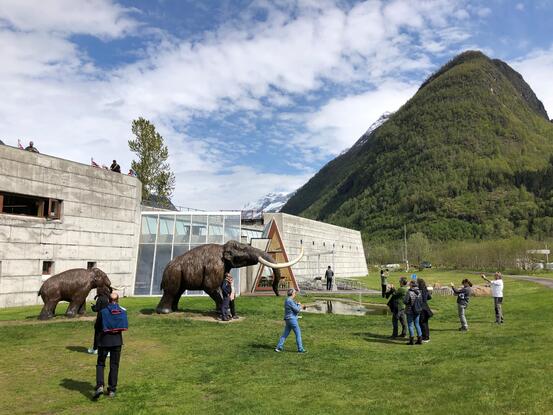 Turistar ved mamuttskulpturane ved bremuseet i Fjærland.