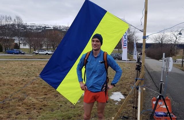Vinner på halvmaraton Lasse Aleksander Finstad foran det ukrainske flagget. Arrangementet både støttet og viste solidaritet med Ukraina. Foto: Sigbjørn Anton Lerstad