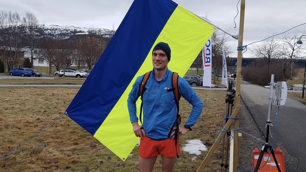 Vinner på halvmaraton Lasse Aleksander Finstad foran det ukrainske flagget. Arrangementet både støttet og viste solidaritet med Ukraina. Foto: Sigbjørn Anton Lerstad