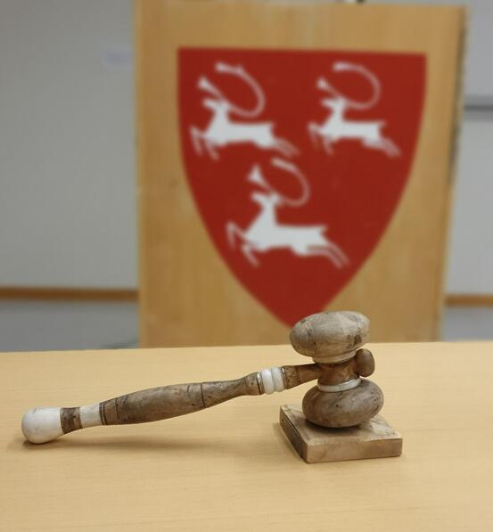 ordførerklubbe forann talerstolen med Porsanger kommunes kommunevåpen på