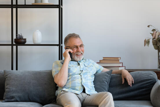 Happy elder grandfather talking on mobile phone