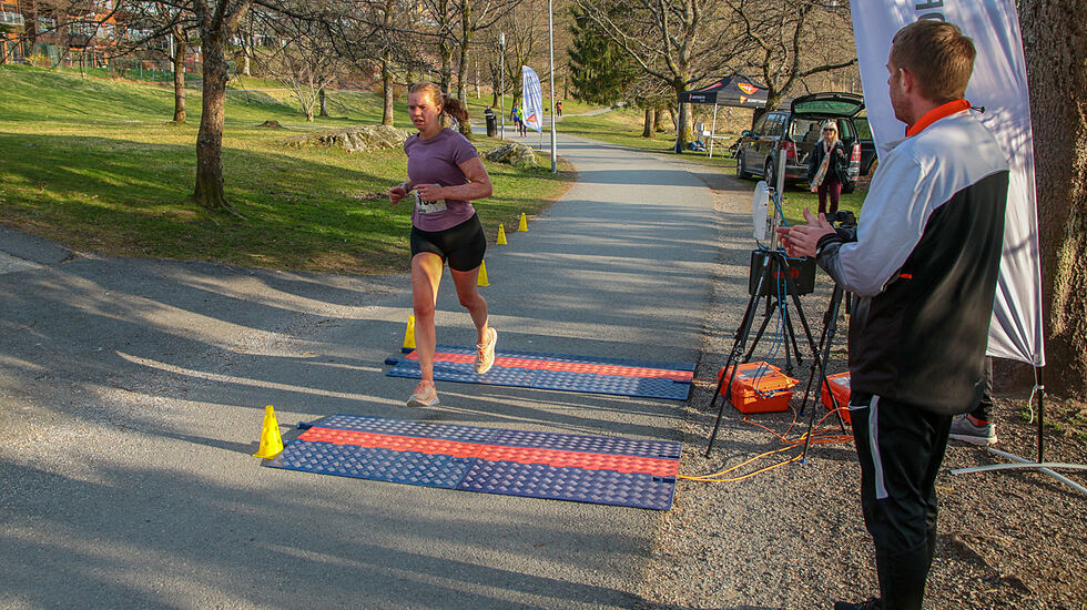 Caroline Thorvik Olsen løper i mål som beste kvinne på 10 km. Christian Jensen i Bedriftsidretten Vestland heier henne inn. (Alle foto: Arne Dag Myking)