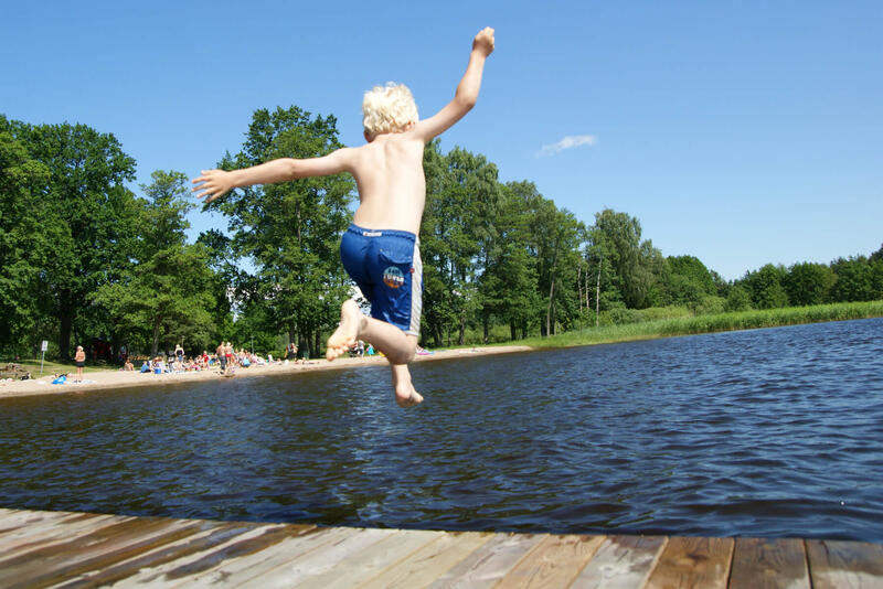 Illustrasjonsbilde av et barn som hopper fra en brygge. Foto: Mostphotos.com/Michael Erhardsson