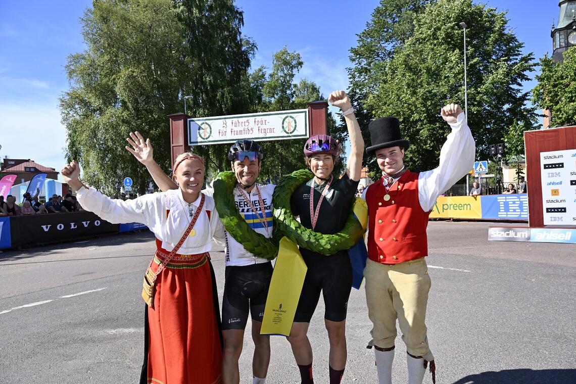 Vinnerne av Cykelvasan 2022, Emil Lindgren og Sandra Salinger, sammen med kranskullan og kransemasen. (Foto: Vasaloppet/ Nisse Schmidt)