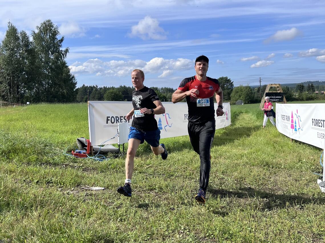 Thomas Rønningen (til venstre) og Robert Paulsbyen side om side over mål etter 8 km med hindringer i tøft terreng. (Foto: Arrangøren)