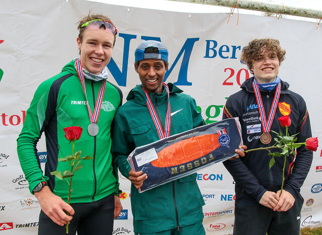 Premiepallen menn junior: Vebjørn Hovdejord, Abdulahi Dahir Rabi og Esten Hansen-Møllerud Hauen. Her var det også spiselige premier. (Foto: Arne Dag Myking)