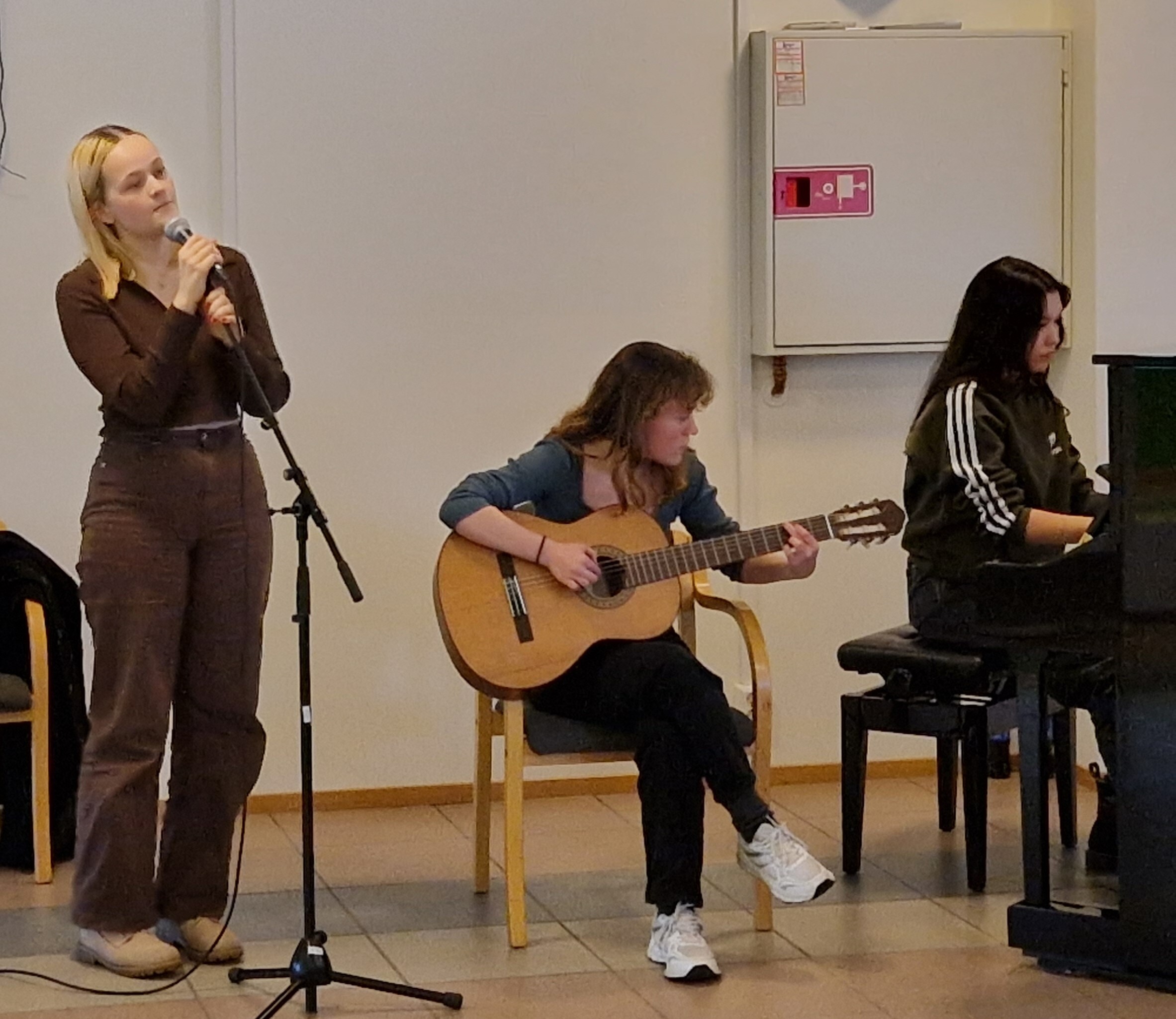 Bilde av 3 elever ved Askim videregående skole som synger ved erkjentlighetsgaveutdelingen 2022
