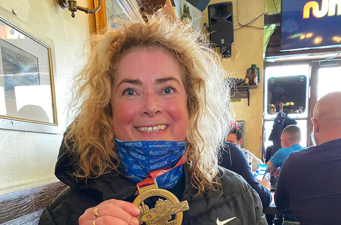 Marianne Telle med medaljen hun fikk etter sin halvmaraton nummer seks i Praha, byen som er hennes favorittsted å løpe. (Foto: privat) 