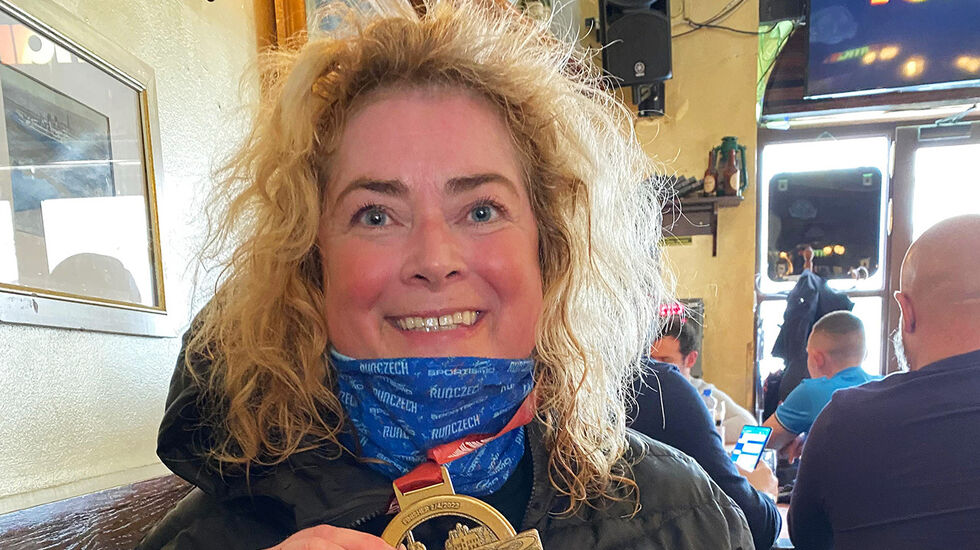 Marianne Telle med medaljen hun fikk etter sin halvmaraton nummer seks i Praha, byen som er hennes favorittsted å løpe. (Foto: privat)