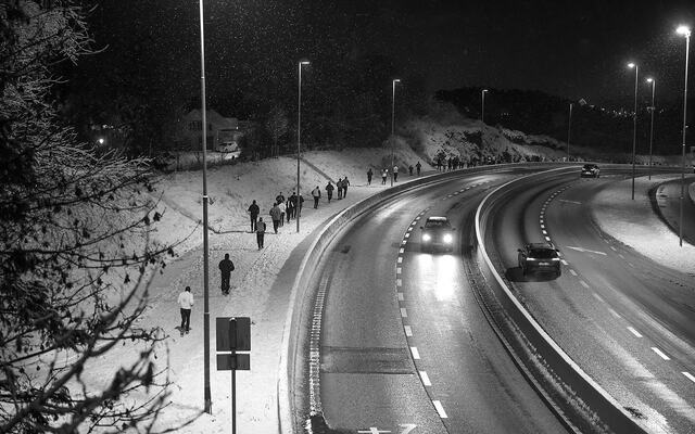 Løperne beveger seg oppover Flyplassveien på snødekke og med lette snøfnugg i luften. (Alle foto: Arne Dag Myking)