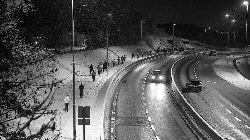 Løperne beveger seg oppover Flyplassveien på snødekke og med lette snøfnugg i luften. (Alle foto: Arne Dag Myking)