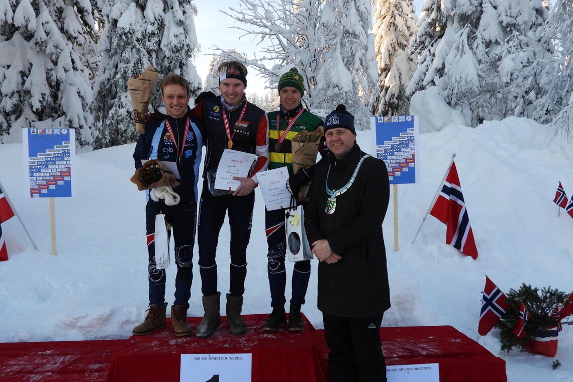Ordfører i Åmot, Ole Erik Hørstad delte ut medaljer og premier. Her sammen med medaljevinneren i H21. (Foto: Stein Arne Negård)