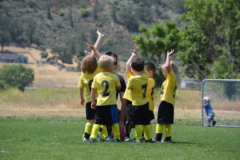Illustrasjonsbilde: Barn på fotballbanen i samtale med trener. Foto: Pixabay.com/luvmybry