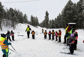 Barna står i ring med ski på bena