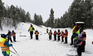 Barna står i ring med ski på bena